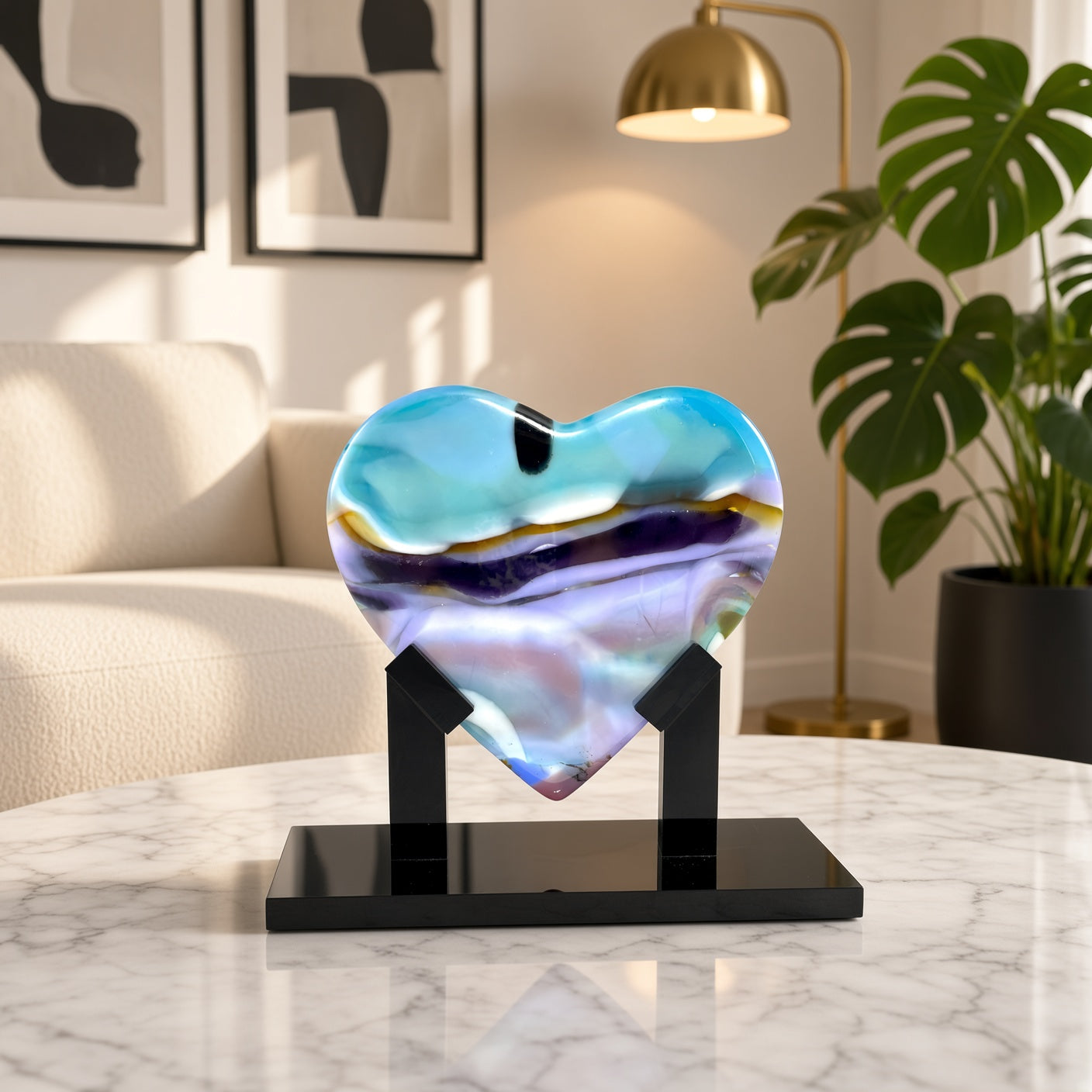 Aqua, purple, and gold fused glass heart sculpture on black stand, staged on a marble table in a modern living room - Arctic Skies handmade art glass gift