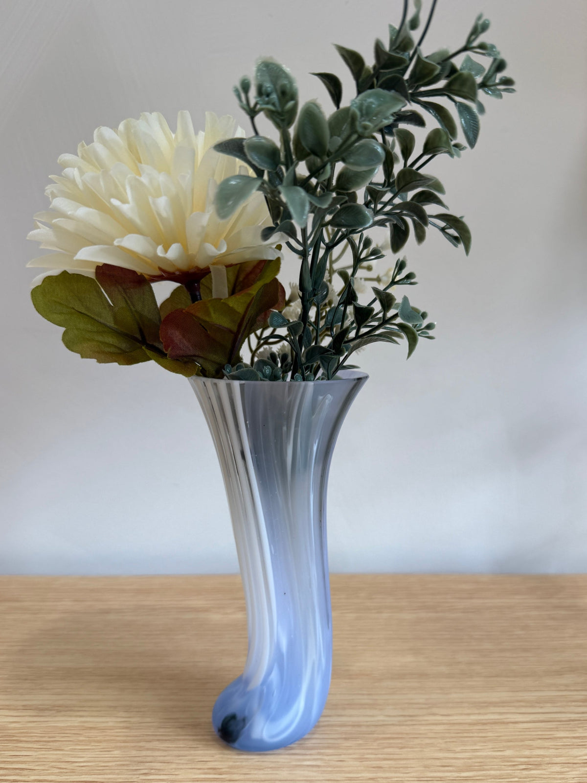 Handmade Pastel Glass Vase with flowers on a wooden surface against a plain background