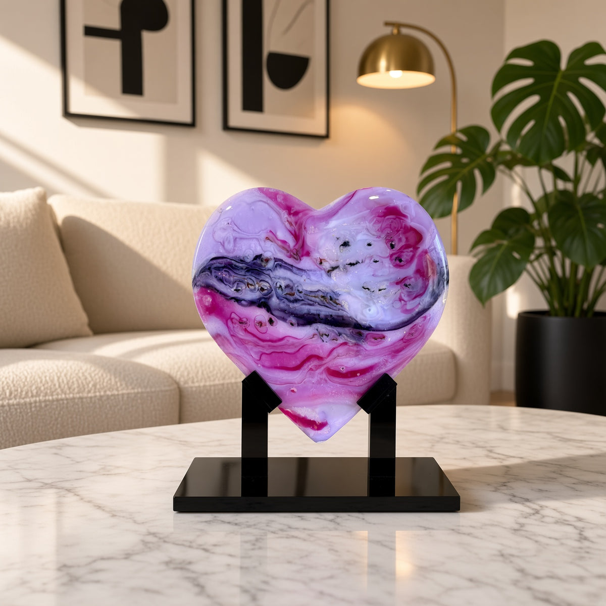 Pink, purple, and white marbled glass heart sculpture on a black stand on a marble table in a modern living room - handmade fused art glass keepsake