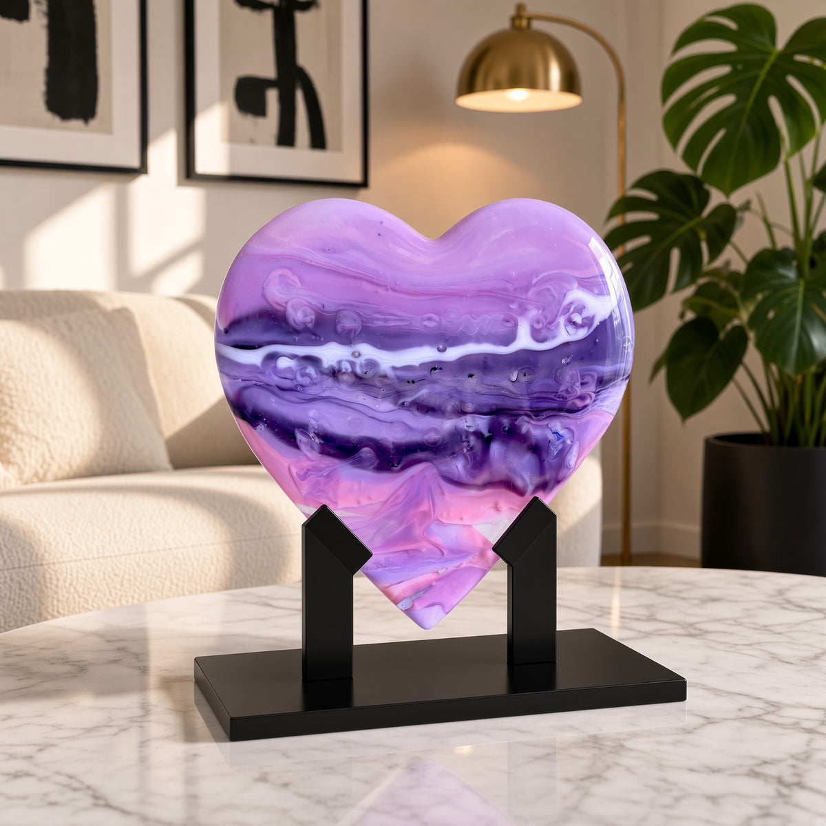 Purple, pink, and white marbled glass heart sculpture on a black stand on a marble table in a modern living room - handmade fused art glass keepsake