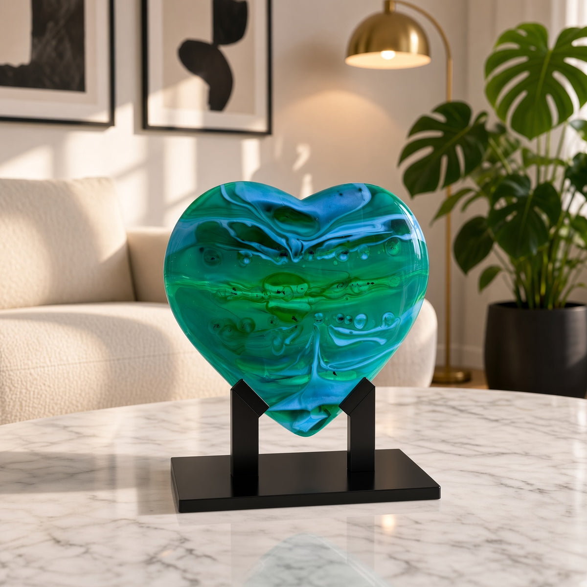 Emerald Tide green fused glass heart sculpture on a black stand, styled on a marble table in a modern living room — handmade art glass decor.