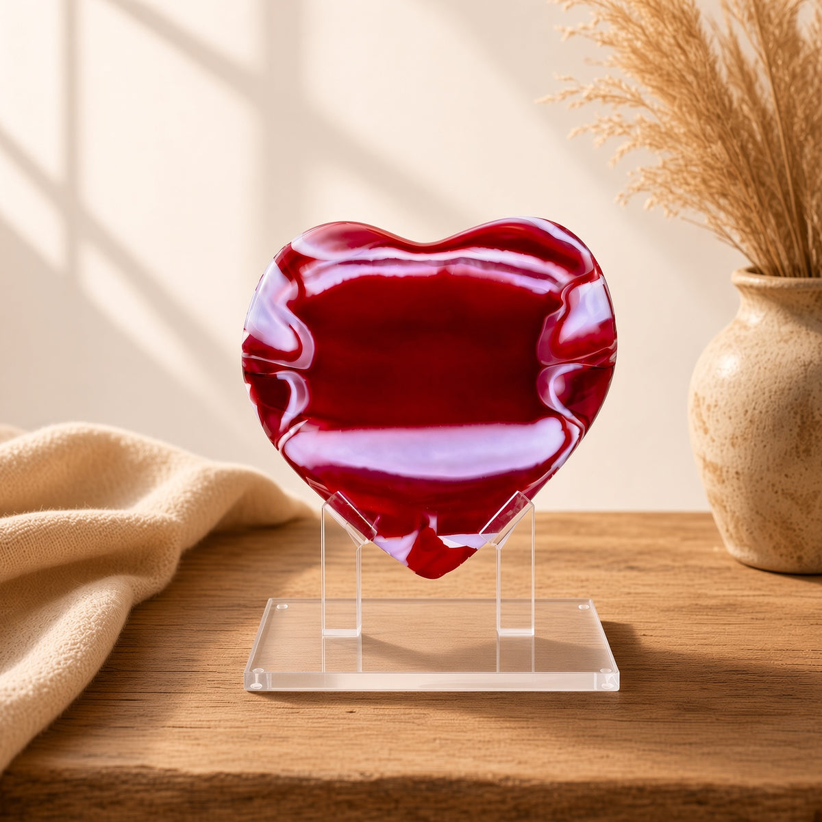 Red Glass Heart Sculpture on a clear acrylic stand on a wood table - handmade fused art glass keepsake